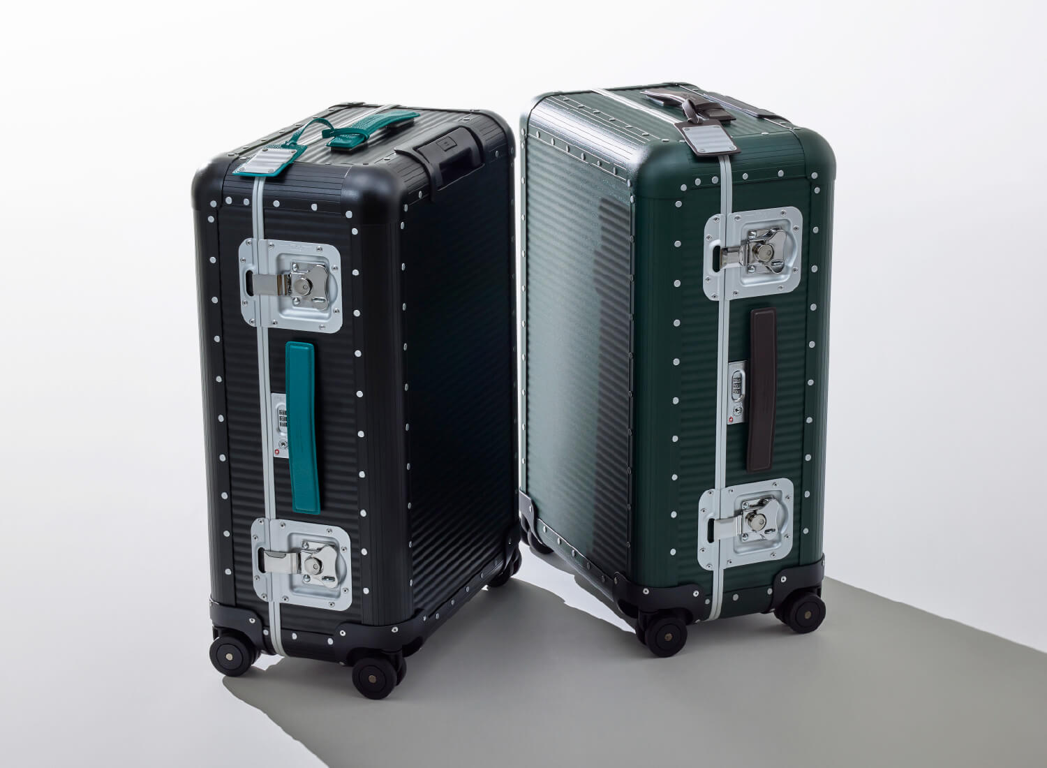 ブラックのトランクにターコイズのレザーハンドルを装着したイメージと、グリーンのトランクにブラウンのレザーハンドルを装着したイメージ